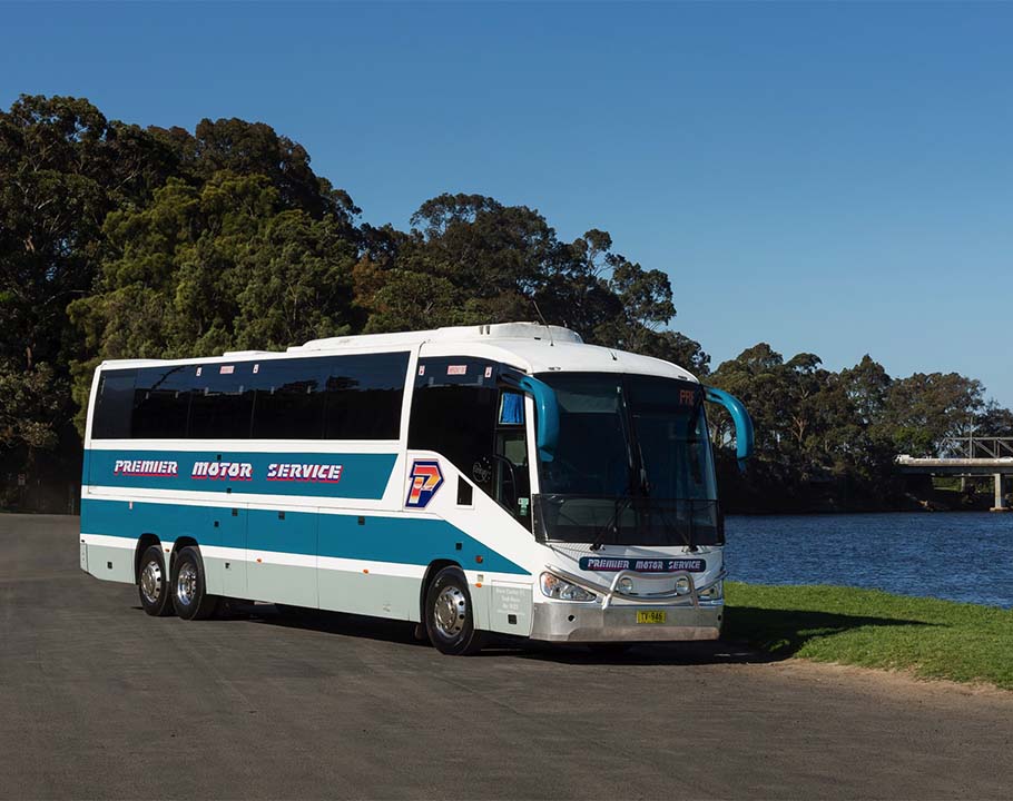 Premier Queensland coach in front of lake